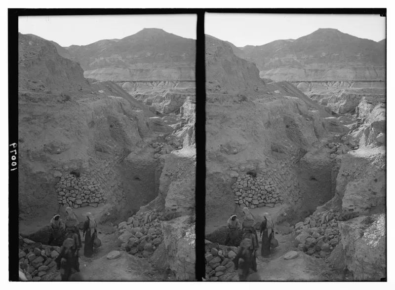 The excavated wall at ancient Jericho, photographed in the 1930s, with the Mount of Temptation behind