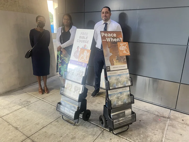 Witnesses at a public literature stand; a removed person may now be offered a greeting