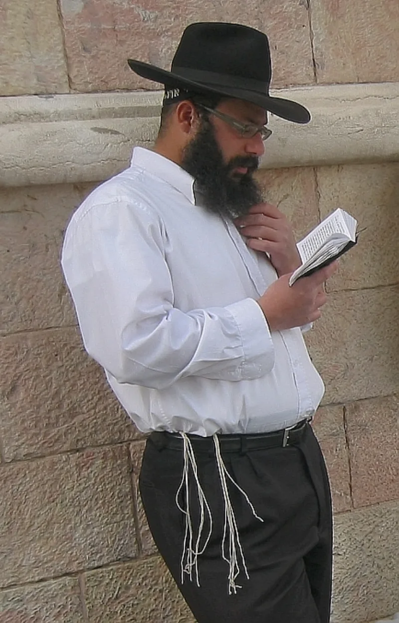 A man wearing a tallit katan, the fringed undergarment the church offers as its biblical analogue